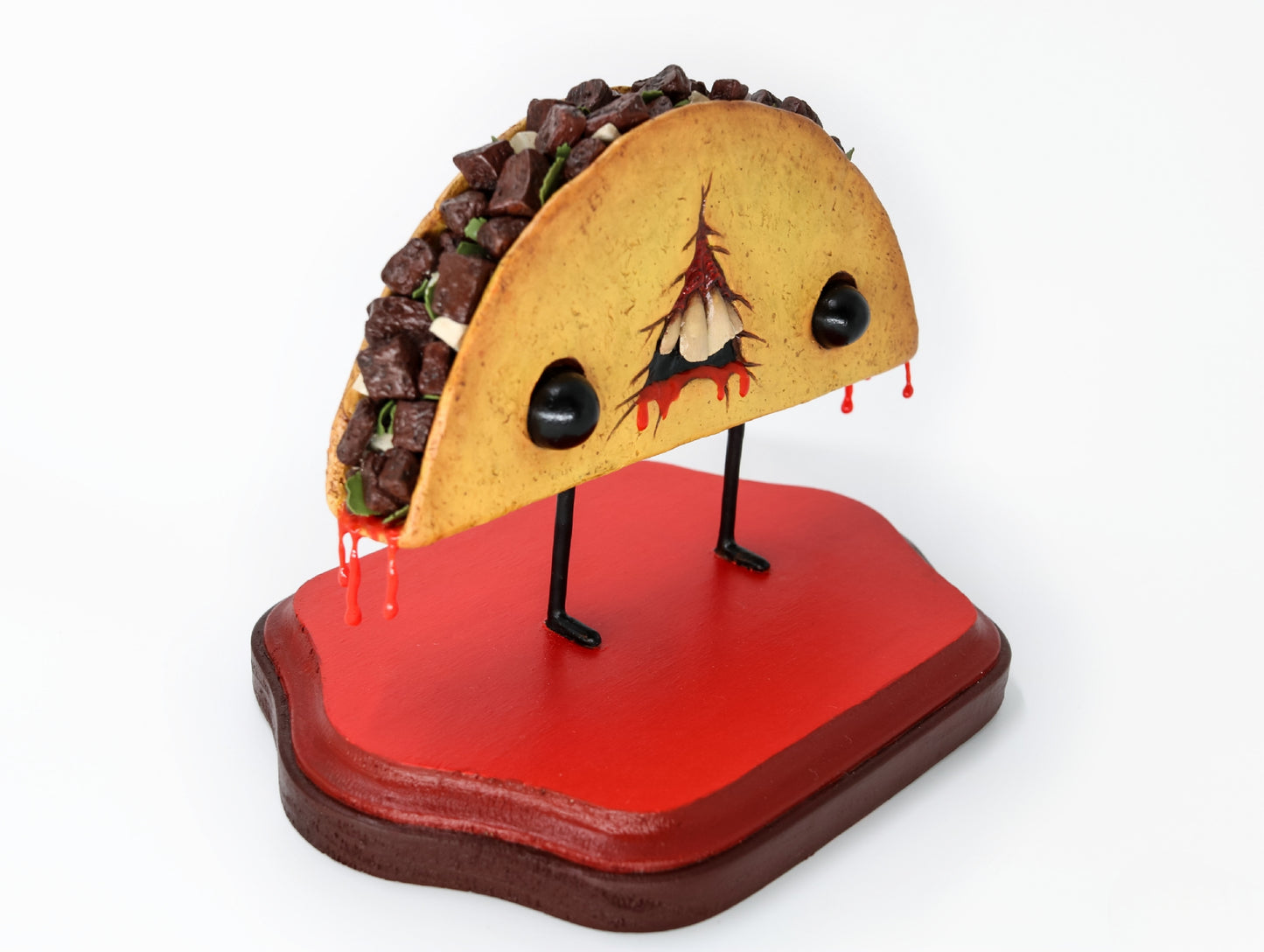Three-quarter angle showing taco sculpture's face, eyes, and toppings